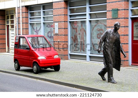 AMSTERDAM, NETHERLANDS - AUGUST 10, 2014: Tiny car Canta LX at the city street near the statue of a pedestrian.