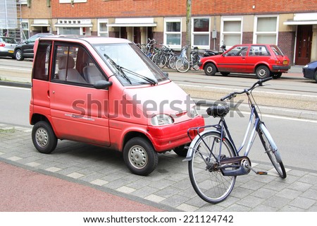 AMSTERDAM, NETHERLANDS - AUGUST 10, 2014: Tiny car Canta LX at the city street near the bicycle.
