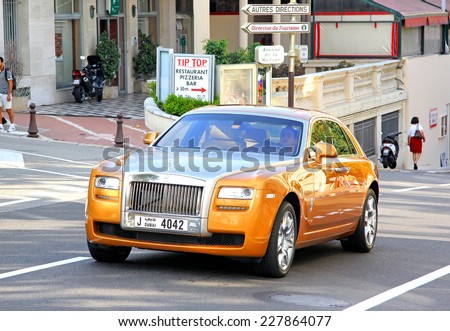 MONTE CARLO, MONACO - AUGUST 2, 2014: Orange and silver luxury car Rolls-Royce Ghost at the city street near the casino.