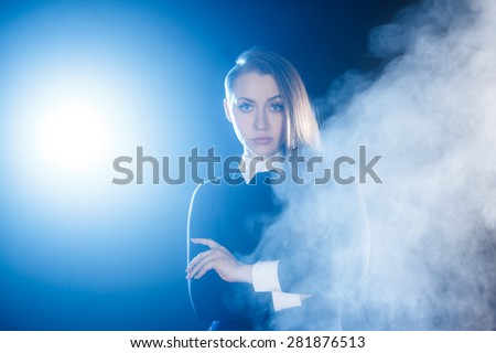 Beautiful young woman behind the cloud of smoke
