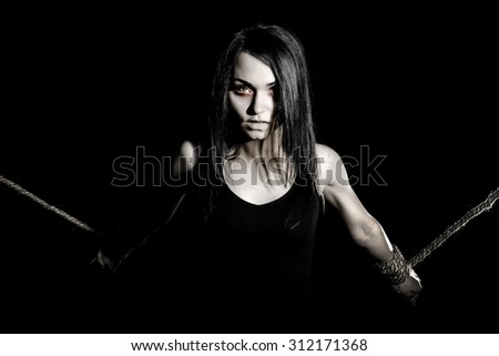 Pale woman with tied arms over black background
