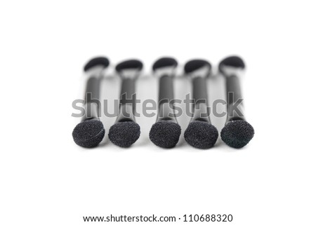 Close-up of five black make-up applicators isolated on white background
