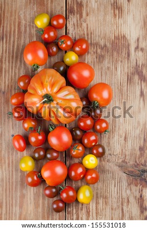 Yellow, red and black tomatoes on wooden background