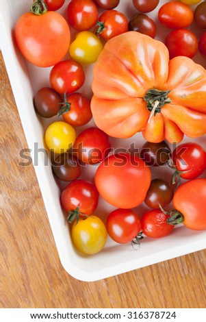 Yellow, red and black tomatoes on baking sheet