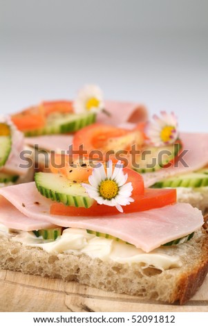 Healthy spring sandwiches with ham, tomato, cucumber and cream cheese seasoned with freshly ground pepper
