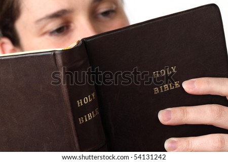 Young woman reading the Bible. Focus on the Bible