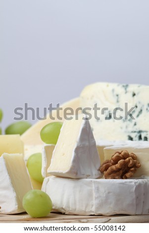 Various kinds of cheese with walnuts and grapes