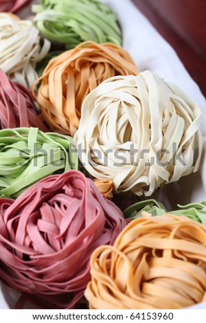 Assortment of colorful tagliatelle pasta dyed with natural dye from carrots, potatoes, spinach and beetroot