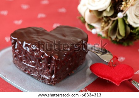 Heart shaped chocolate cake with heart decoration and bouquet