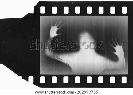 Old scratched and damaged negative film with silhouette of screaming person, isolated on white background