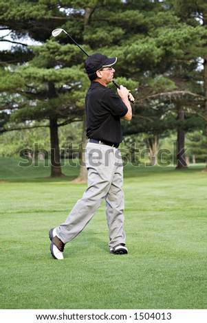 Male golfer on course completed a drive.