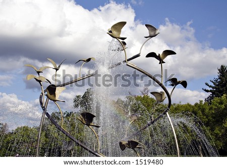 Fountain at a public park - bird sculpture - Rainbow in waterspray,  lower center
