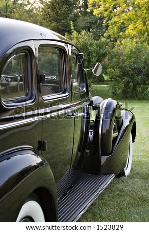 Side view of a vintage black Buick Sedan.  1930's?  Running board, fender, white all tires.