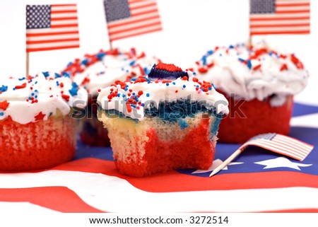 A red, white and blue striped cupcake with a bite taken.