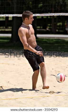 A young college age male playing volleyball on summer break.