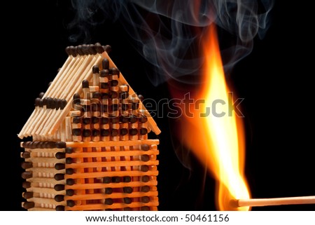 House build from matches on fire with black isolated background