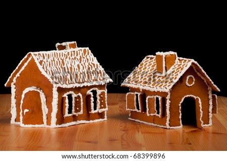 Two Isolated christmas gingernut house on wooden table