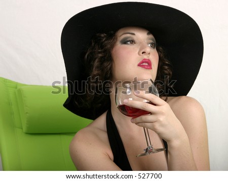 Young woman with old fashioned hat drinking wine
