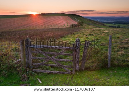 Stunning Summer sunset over countryside rural landscape towards setting sun