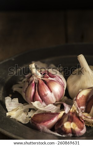 Fresh garlic cloves in moody natural lighting set up with vintage style