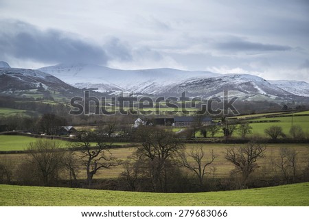 Countryside landscape with snow covered mountain range in distance
