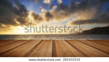 Stunning landscape ocean at sunset dramatic clouds with wooden planks floor