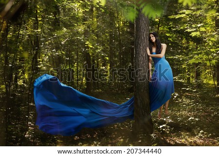 Beautiful woman flying up in forest. Magic. Miracle. Fantasy.