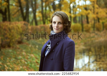 Beautiful young woman posing in autumn park