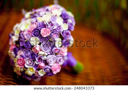 Purple wedding bouquet in a wicker chair