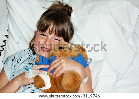 little girl in hospital bed with teddy bear