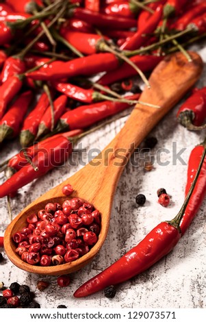 chili peppers and black peppers in spoon