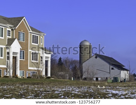 Contrast in lifestyles and architecture in northern Illinois: farm silo and barn of yesteryear near contemporary townhouse
