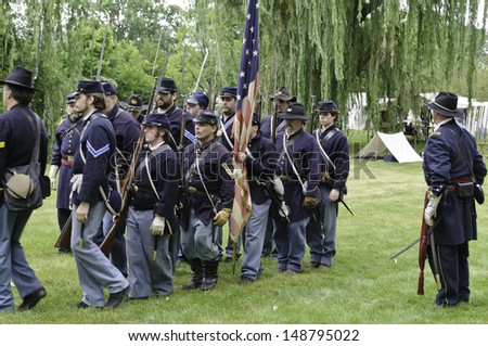 LOMBARD, ILLINOIS/USA - JULY 27: American Civil War (1861-1865) reenactment on July 27, 2013, in Lombard, IL. Union officer watches infantry troops march from camp to a mock battle.