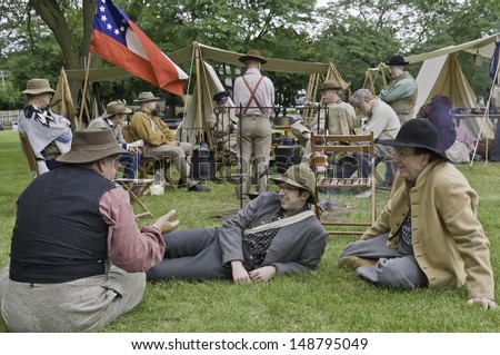 LOMBARD, ILLINOIS/USA - JULY 27: American Civil War (1861-1865) reenactment on July 27, 2013, in Lombard, IL. Rebel-actors tell stories and relax together in Confederate camp before a mock battle.