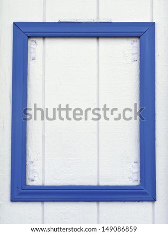 Empty blue frame, fit for your message, on exterior wall of beach concession stand