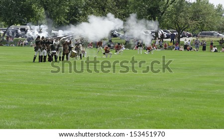 WHEATON, ILLINOIS/USA - SEPTEMBER 7: American Revolutionary War (1775-1783) reenactment on September 7, 2013, in Wheaton, IL. Actor-soldiers fire muskets across mock battlefield in view of spectators.