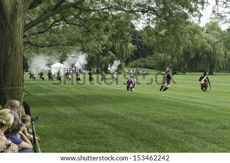 WHEATON, ILLINOIS/USA - SEPTEMBER 7: American Revolutionary War (1775-1783) reenactment on September 7, 2013, in Wheaton, IL. Spectators watch American actor-soldiers fall in mock battle with British.