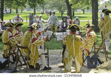 WHEATON, ILLINOIS/USA - SEPTEMBER 7: American Revolutionary War (1775-1783) reenactment on September 7, 2013, in Wheaton, IL. Adult actor-musicians in period dress gets ready to play for teen dancers.