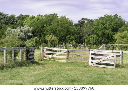 Open gate and fences of wood and wire mesh on Midwestern farm maintained for public education