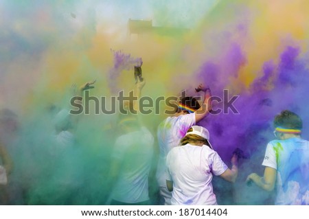 KALAMAZOO, MICHIGAN, USA - April 12, 2014: Runners with powder packets create colorful clouds as they celebrate spring and completion of a 5K run downtown.
