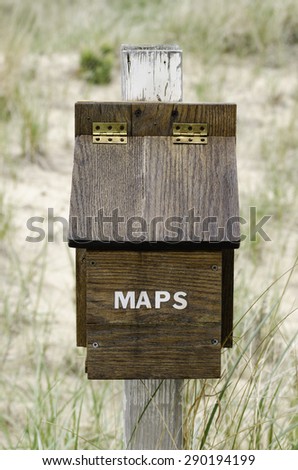 Wooden box that contains free maps year round for hikers, runners, cross-country skiers in recreational dune area in southwestern Michigan, USA