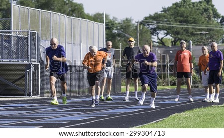 PARK RIDGE, ILLINOIS, USA - July 23, 2015: Three senior runners start their heat of a 50-meter dash while others await their own heat during the Six-County Senior Games in this suburb of Chicago.