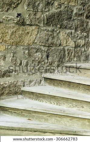 Study in textural contrast: Plain wooden steps against stone wall of campus building