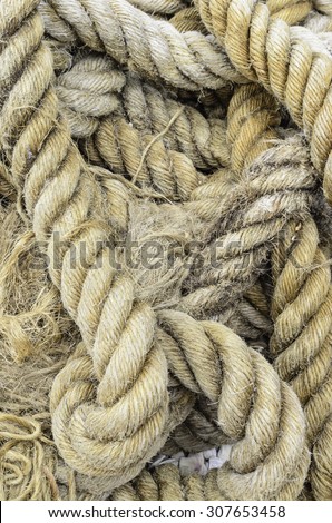 Detail of frayed nautical rope, with a few pebbles at bottom, for background and texture