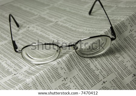 Pair of eyeglasses on financial page of daily newspaper