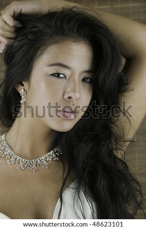 Head shot of pretty young Asian-American woman with unusual catchlights in her dark eyes