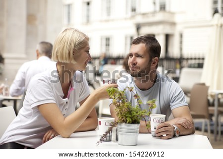 couple having coffee and flirting in street cafe