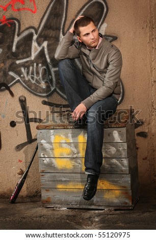 young guy sitting on the sand box ner painted wall