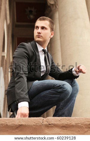 young handsome man posing near old theater