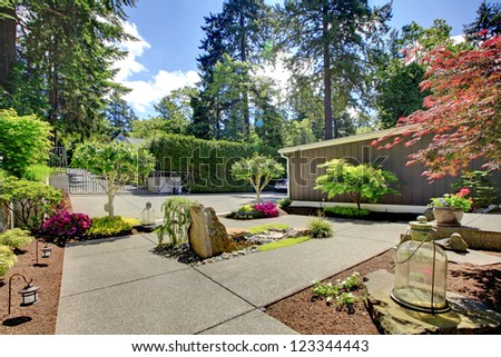 Modern front yard landscape with walkways and rocks.